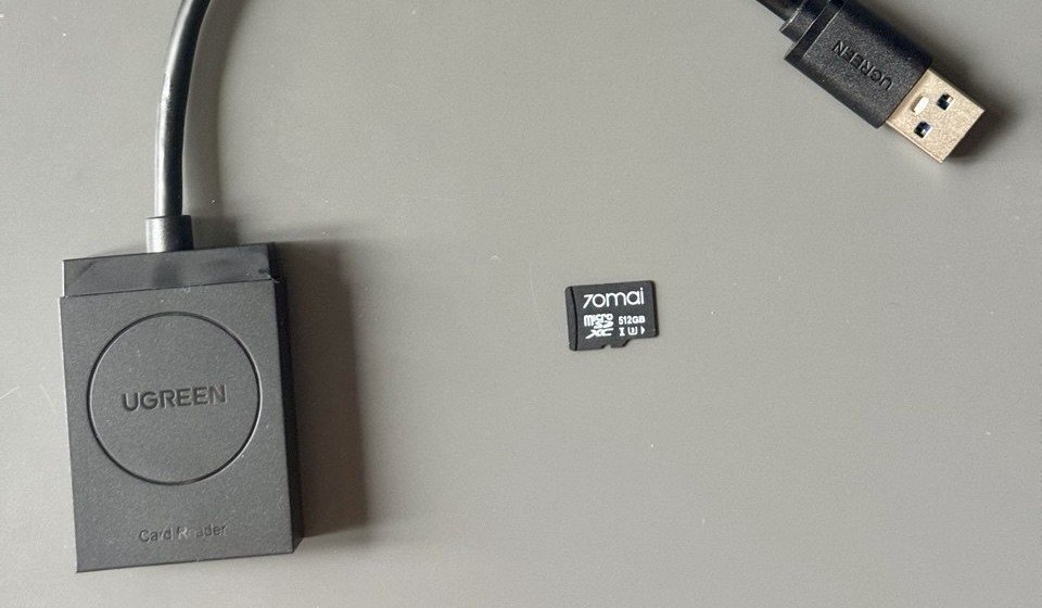 La microSD 70mai da 512GB estratta dalla dashcam accanto al lettore di schede USB